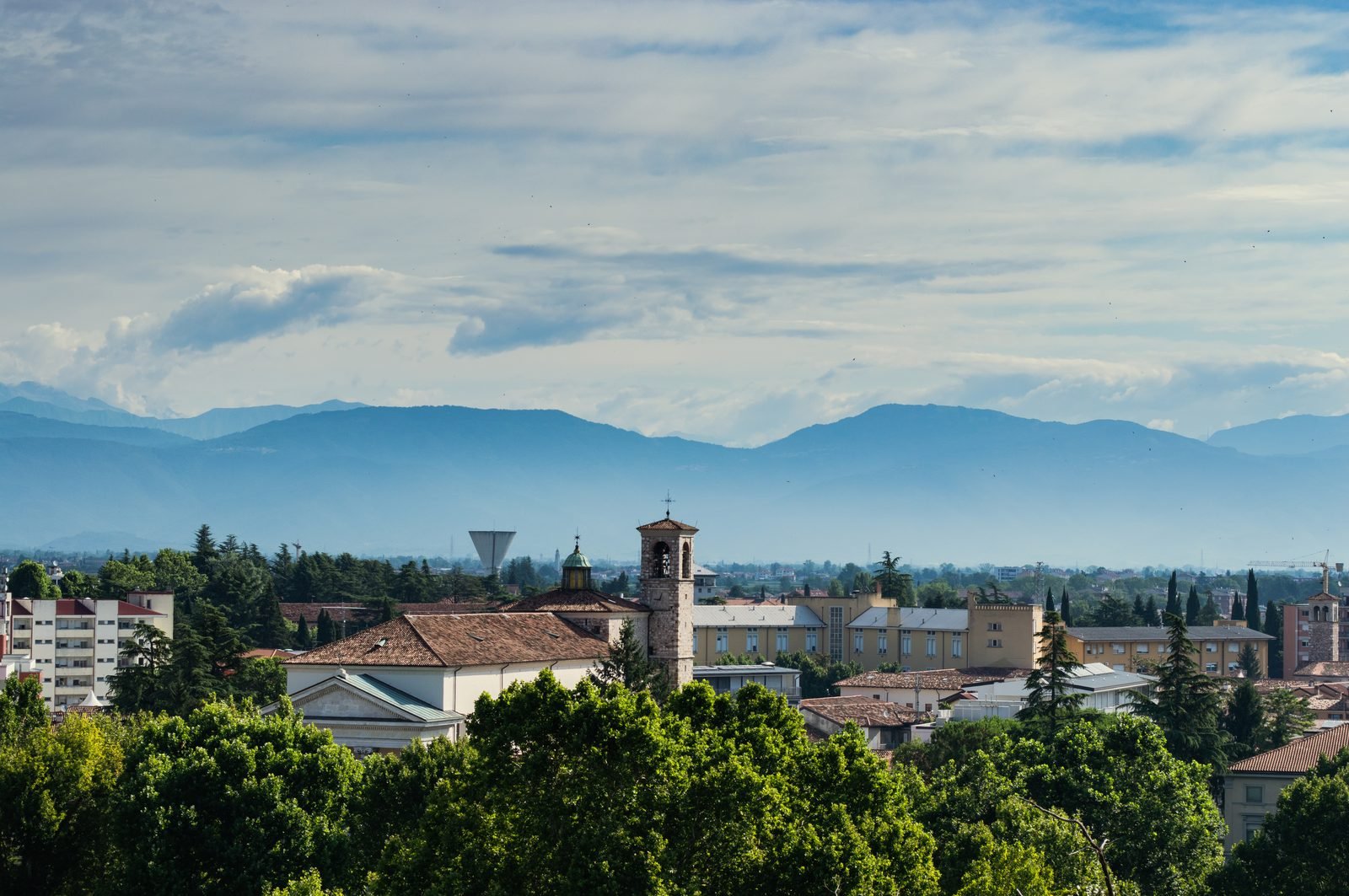 View over Udine's rooftops and bell tower with the Julian Alps beyond